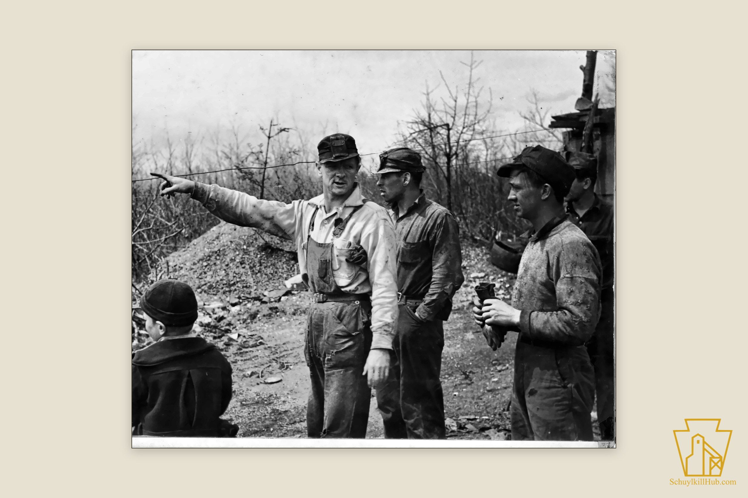 Bootleg coal miners conferring at their hillside diggings while a boy looks on.