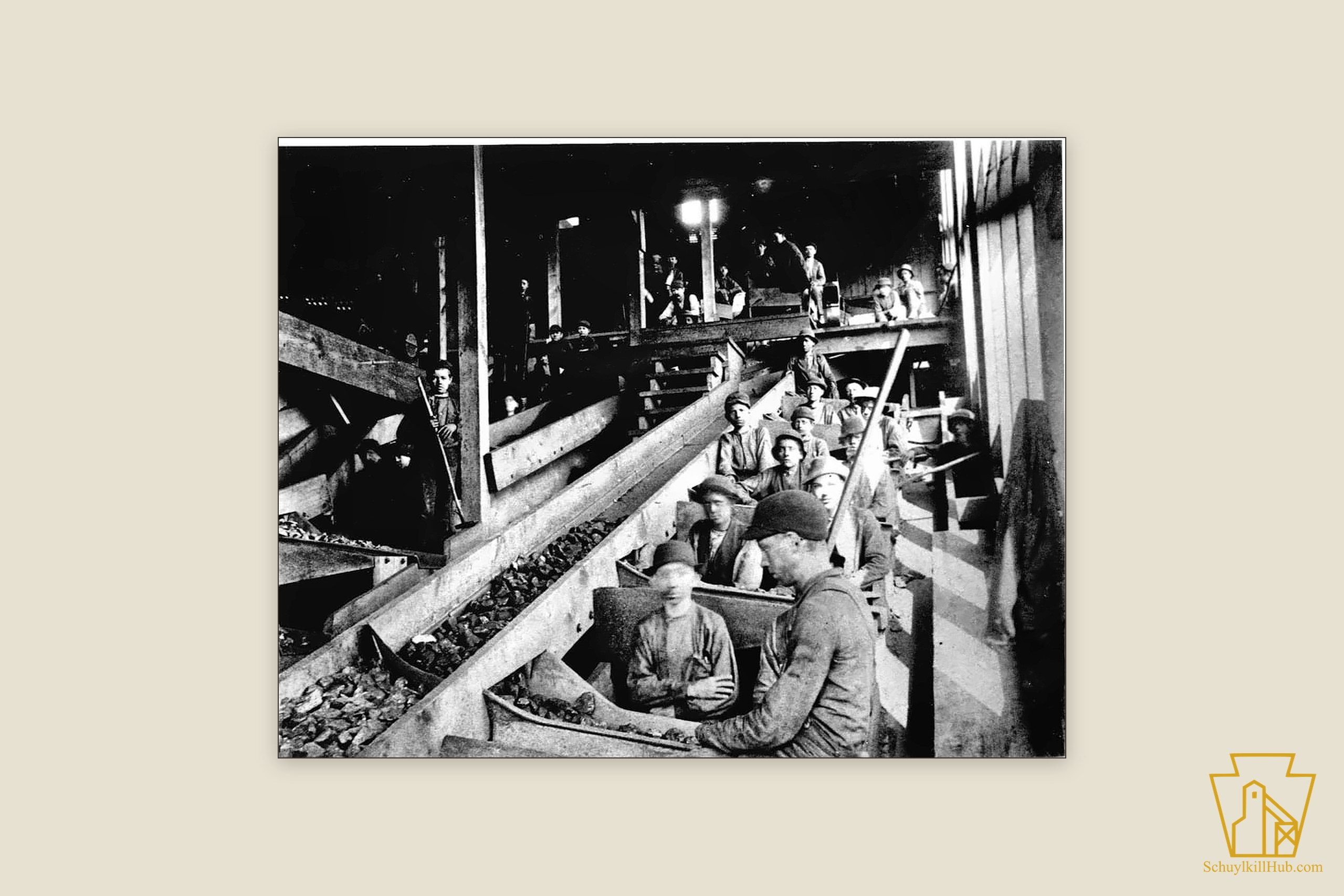 Boys seated along wooden chutes picking slate from coal inside the North Ashland breaker.