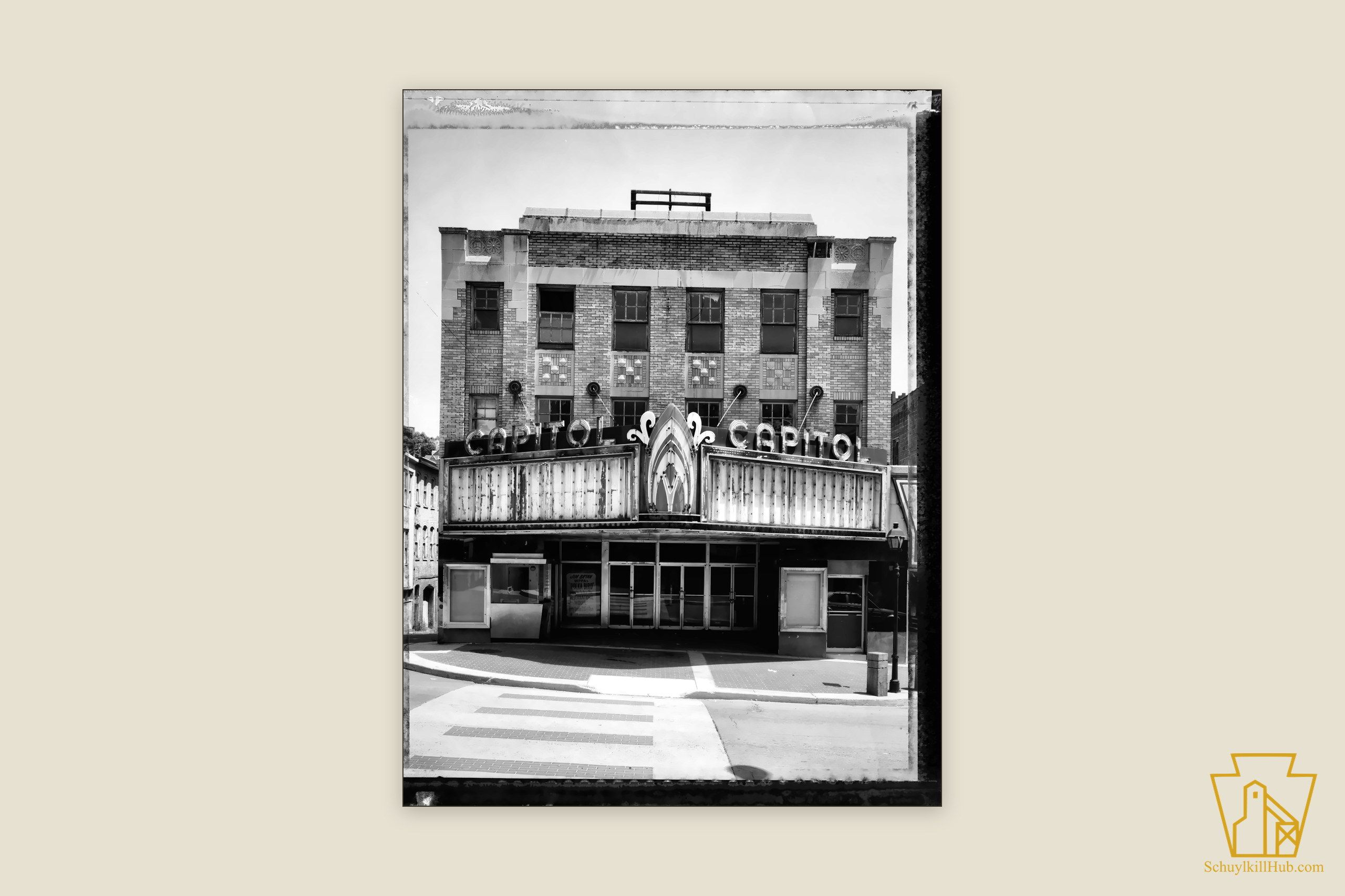 Brick facade of the Capitol Theatre on North Centre Street, its two vertical CAPITOL signs above the marquee.