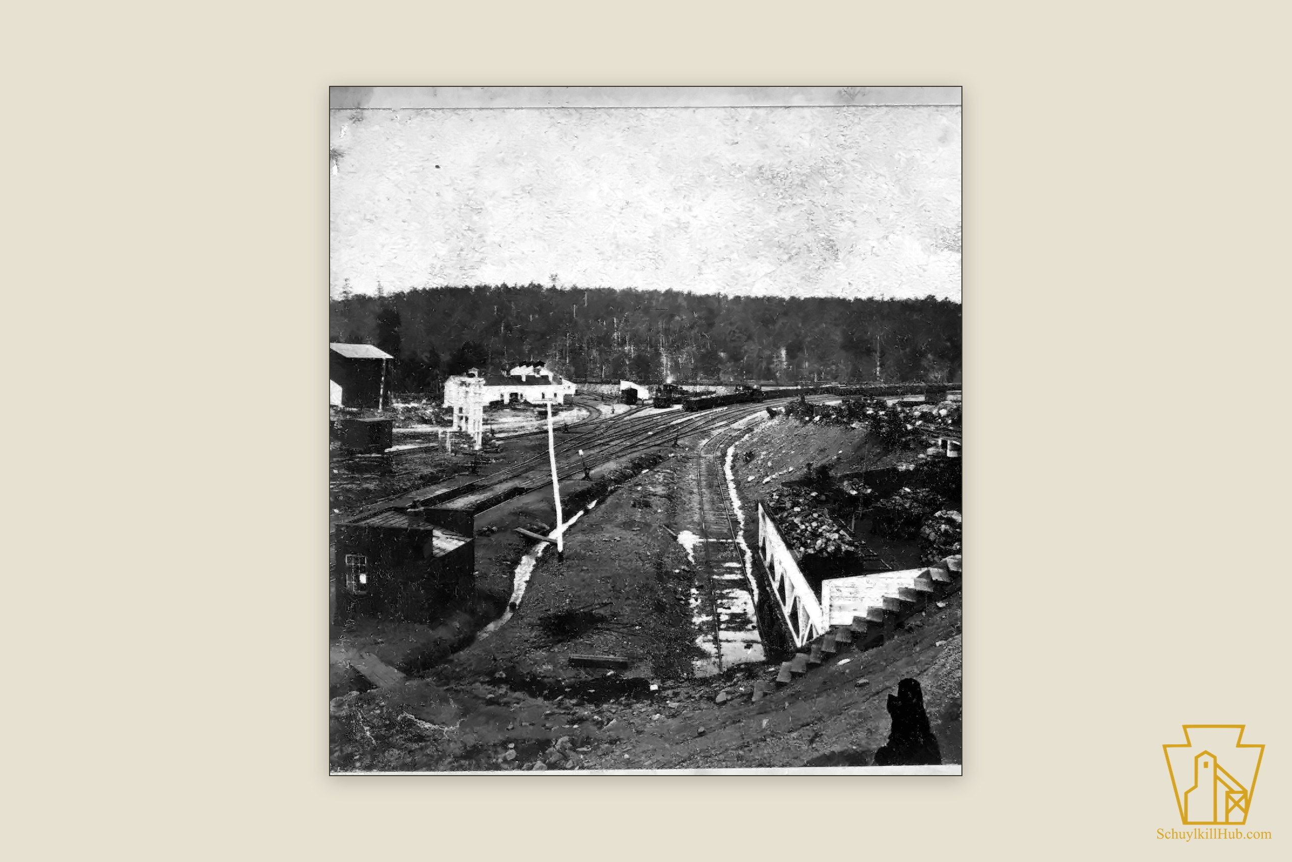 The railroad junction at Gordon — multiple tracks, an arched engine house and coal cars below wooded hills.