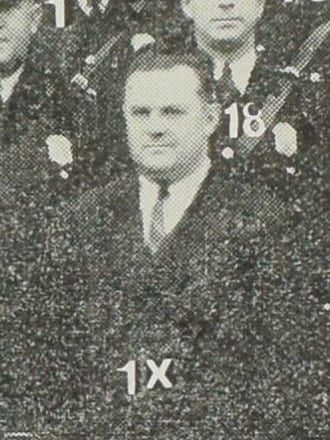 A halftone detail from a 1938 group photograph of the Pottsville police force: Claude A. Lord, a heavy-set, clean-shaven middle-aged man, bareheaded and in a dark civilian suit with a white shirt and dark necktie, standing among uniformed officers in peaked caps. The key number 1X is printed on the photograph below him.