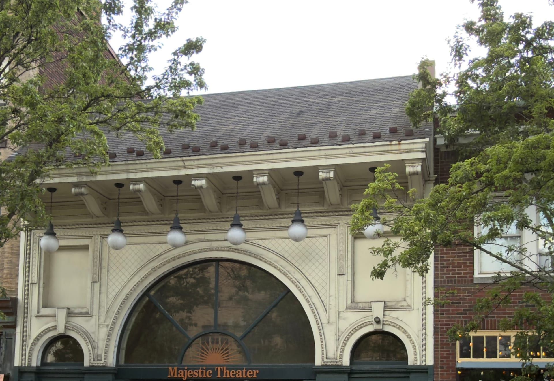 The Beaux-Arts facade of the Majestic Theater on North Centre Street in Pottsville — a wide arched central window with tilework and a row of globe lights along the cornice, above a green storefront lettered 'Majestic Theater.'