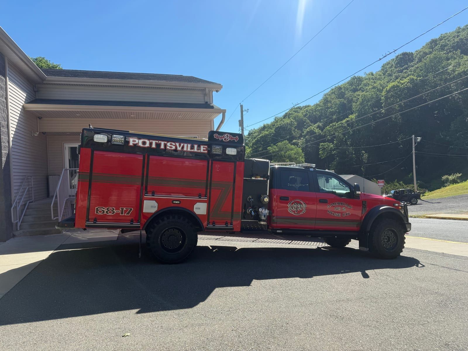A fire engine lettered 'Pottsville' parked beside American Hose Company No. 2's Mount Carbon Station.
