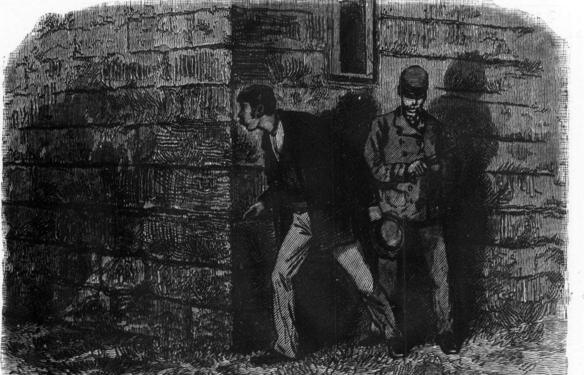 An 1877 wood engraving of two special policemen at night beside the high stone wall of the Schuylkill County Prison: one in a kepi-style cap examines a revolver in his hands while the other, in a sack coat, leans past the wall's corner to peer down the street.