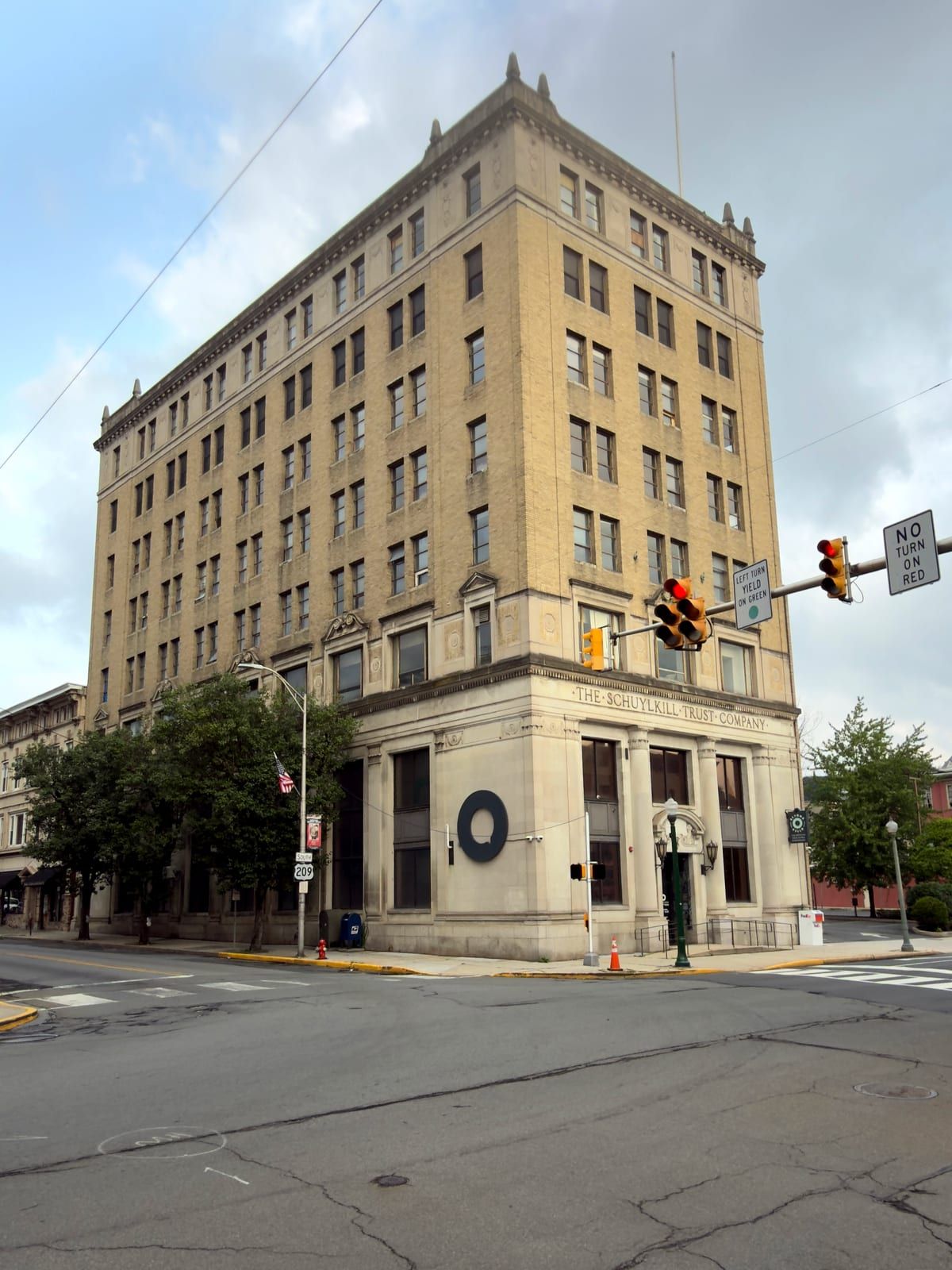 The Schuylkill Trust Company Building on its corner, both street elevations and the stone banking-hall base visible beneath the eight-story brick tower and its ornamented roofline.