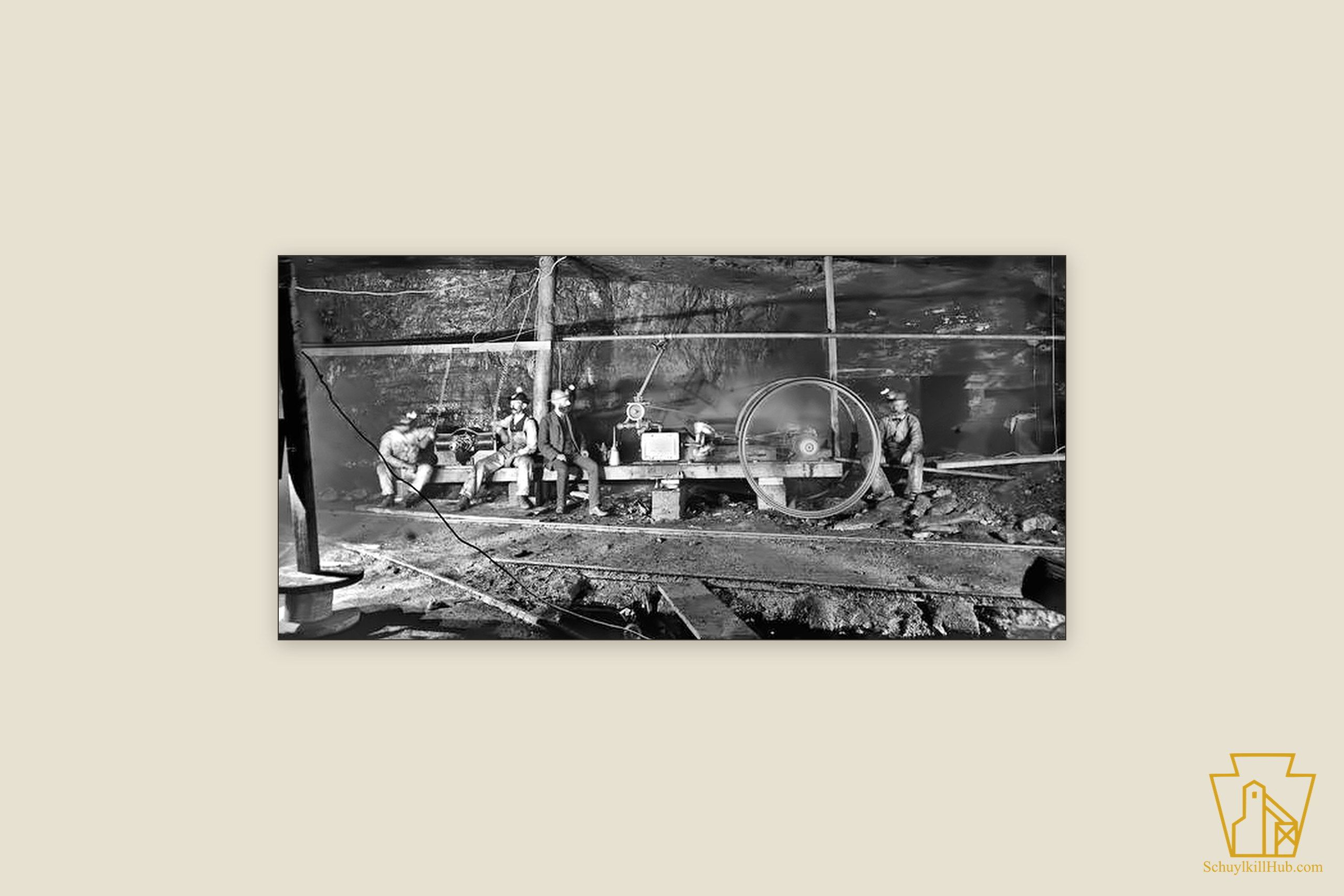 Miners with cap lamps beside an underground hoisting engine, lit by magnesium flash.