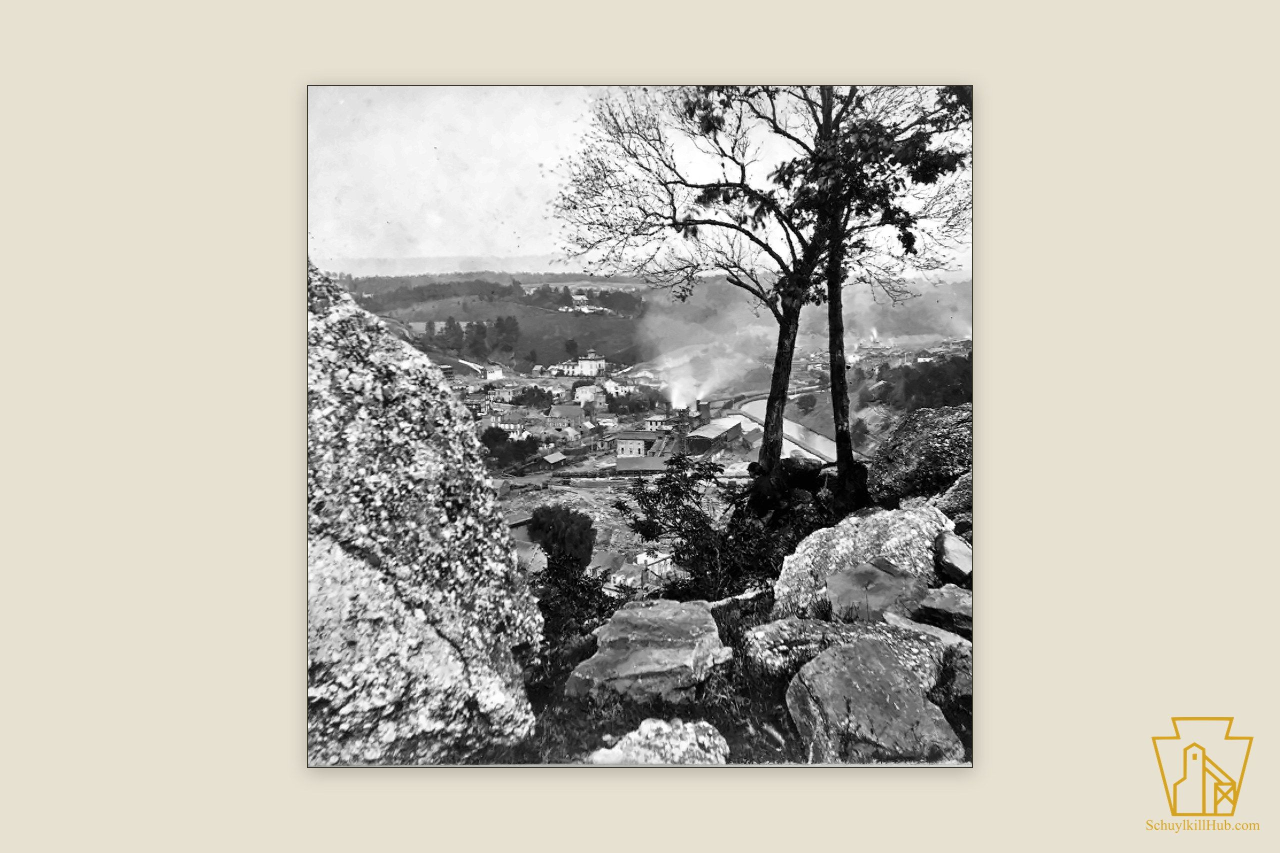 Pottsville seen through trees from the rocks of Sharp Mountain, canal and railroad threading the valley.