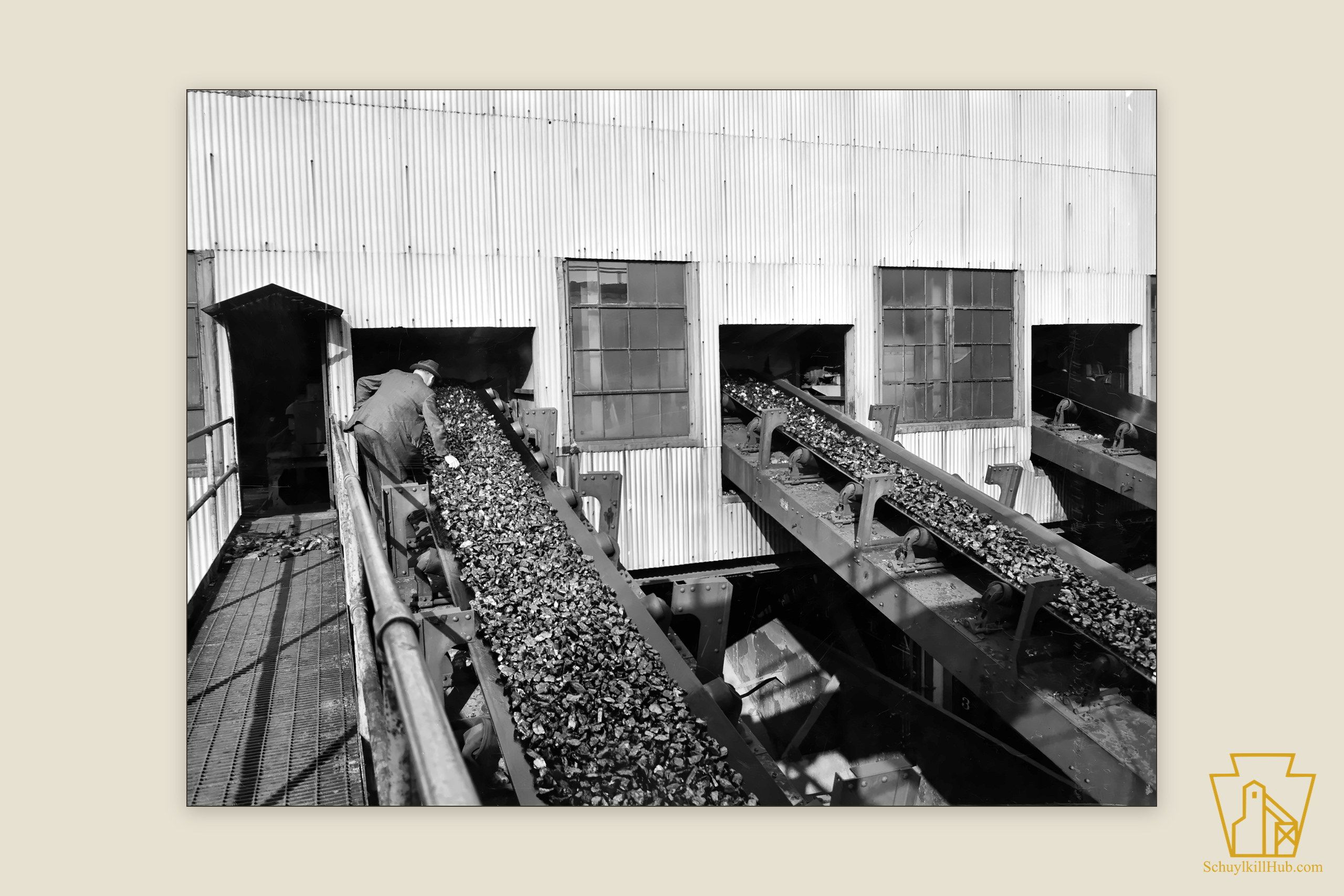 An inspector examining coal on a loading belt inside the St. Nicholas breaker.