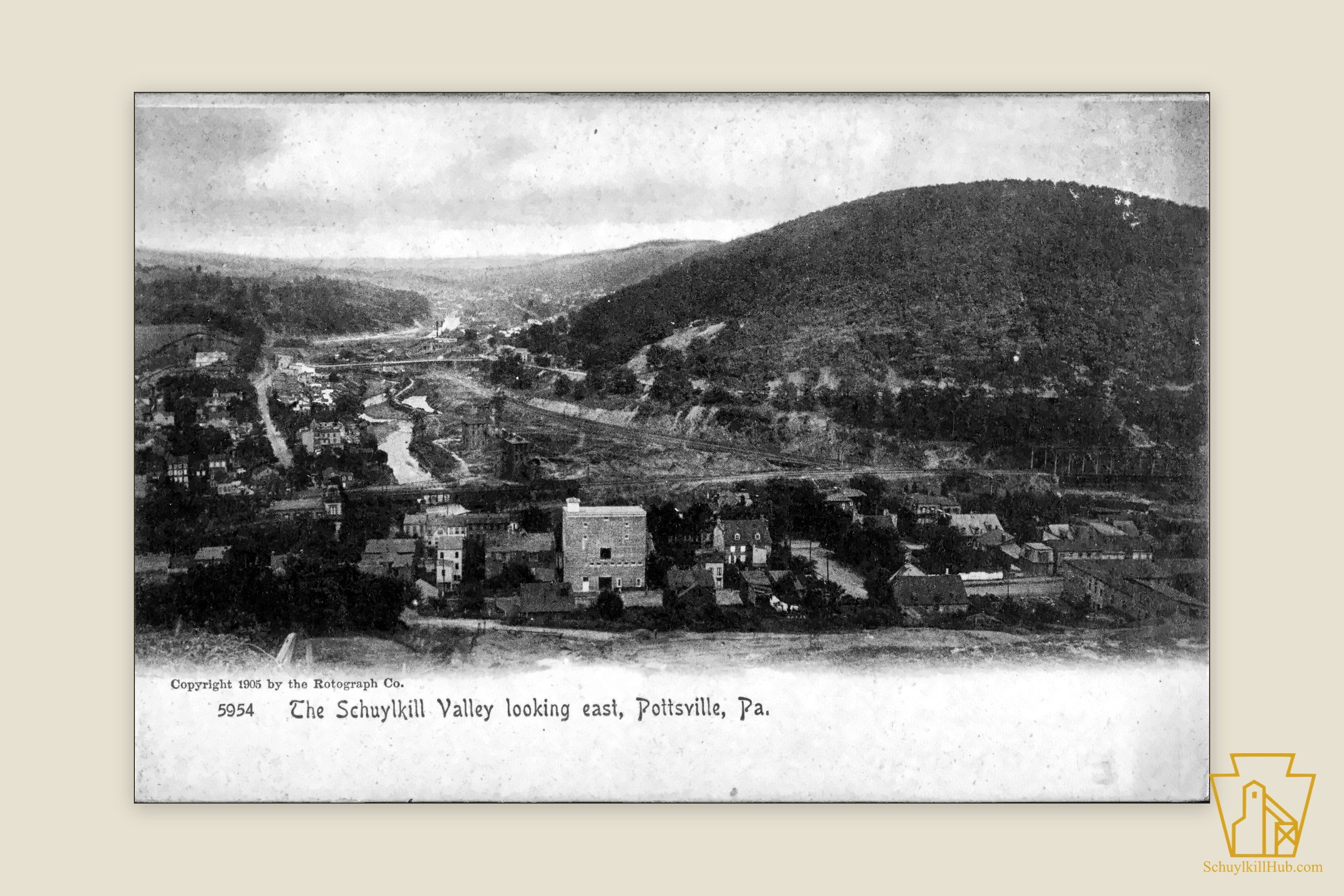 The winding Schuylkill, rail lines and mills below wooded ridges east of Pottsville.