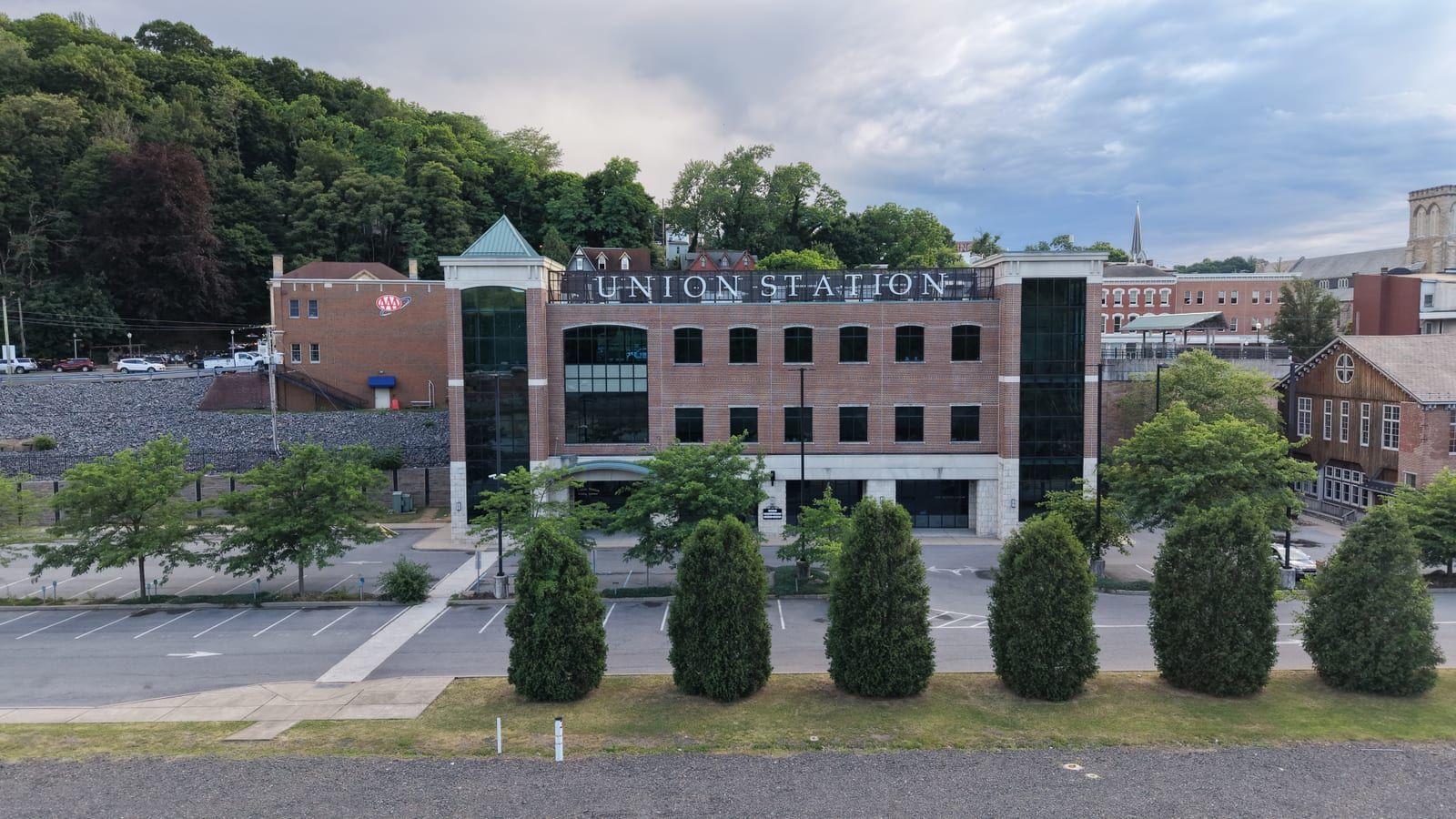 Union Station in downtown Pottsville, Pennsylvania — a four-story brick building with a glass entrance tower, beside the rail yard.